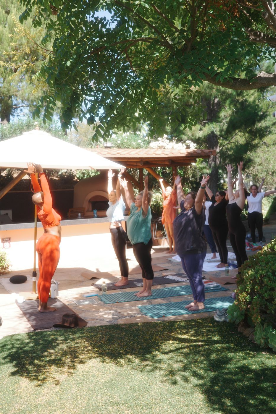 Poolside yoga session under white umbrellas