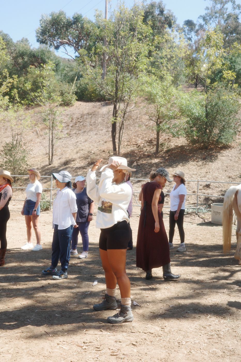 Women standing with the horses in the corral at Shakti Ranch