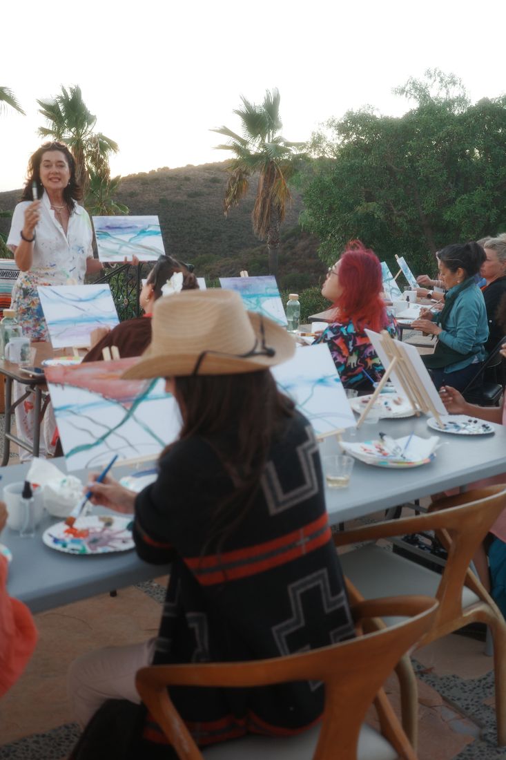 Guests painting at easels during the creative workshop