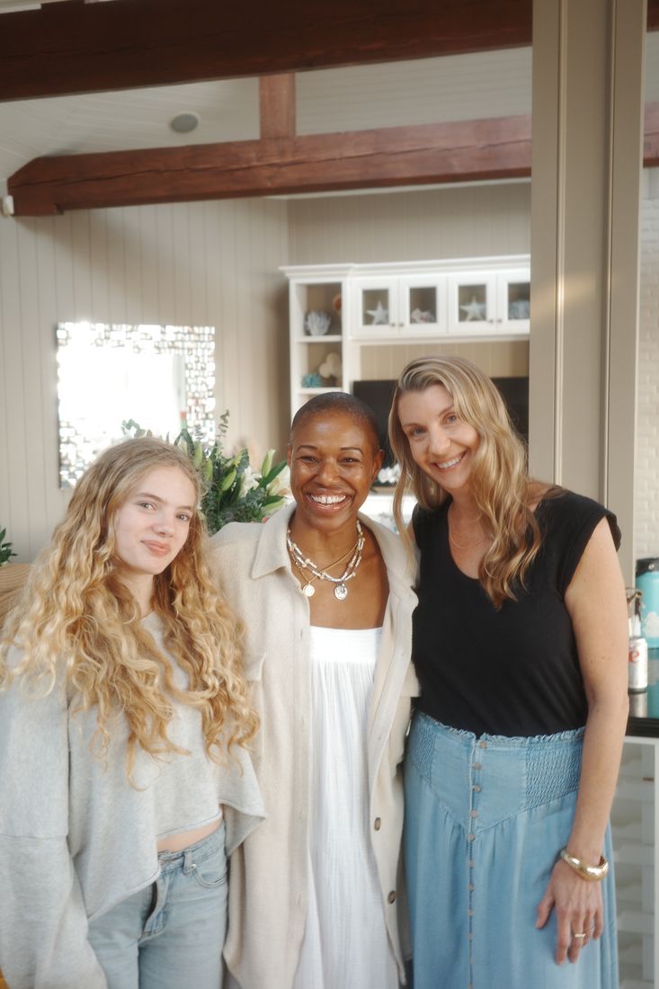 Three guests smiling together in the house