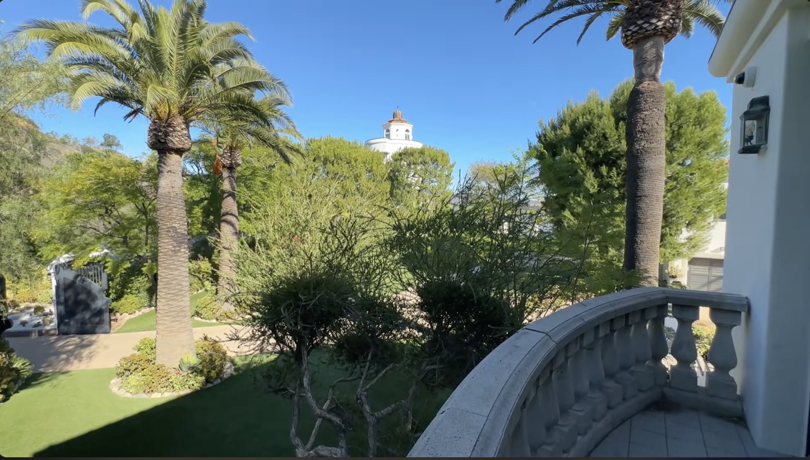 The garden view from the balcony, out over palms and a domed tower