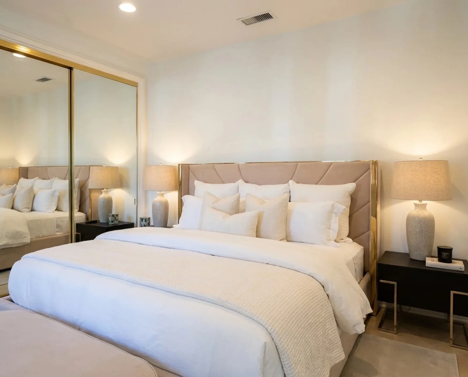 The Blush Room: a shared bedroom with a blush velvet king bed, mirrored gold closet, and soft light