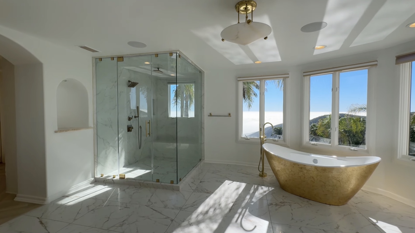 Ensuite bath one: a gold-leaf freestanding soaking tub and a large marble steam shower