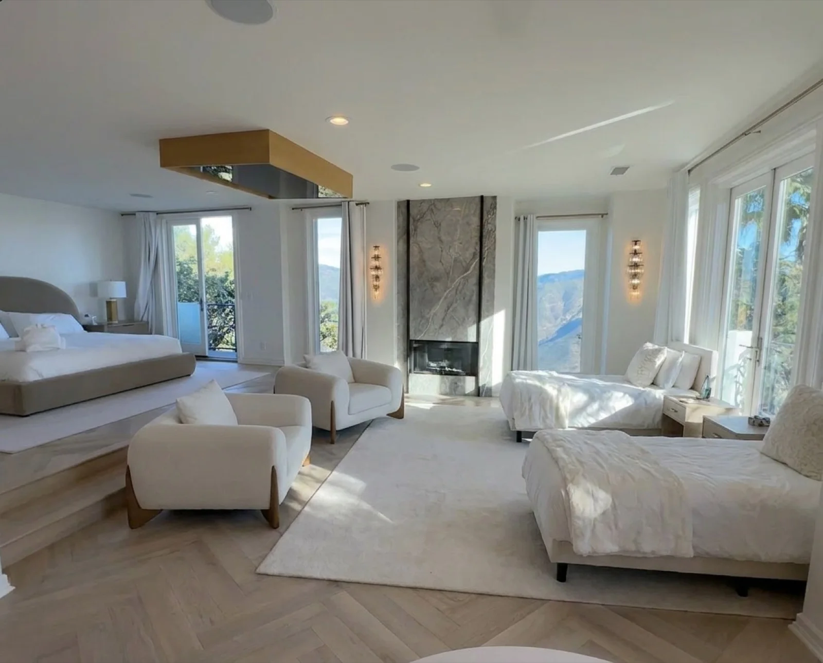 The Master Suite: a king bed, marble fireplace, sitting area, and ocean views past the balcony