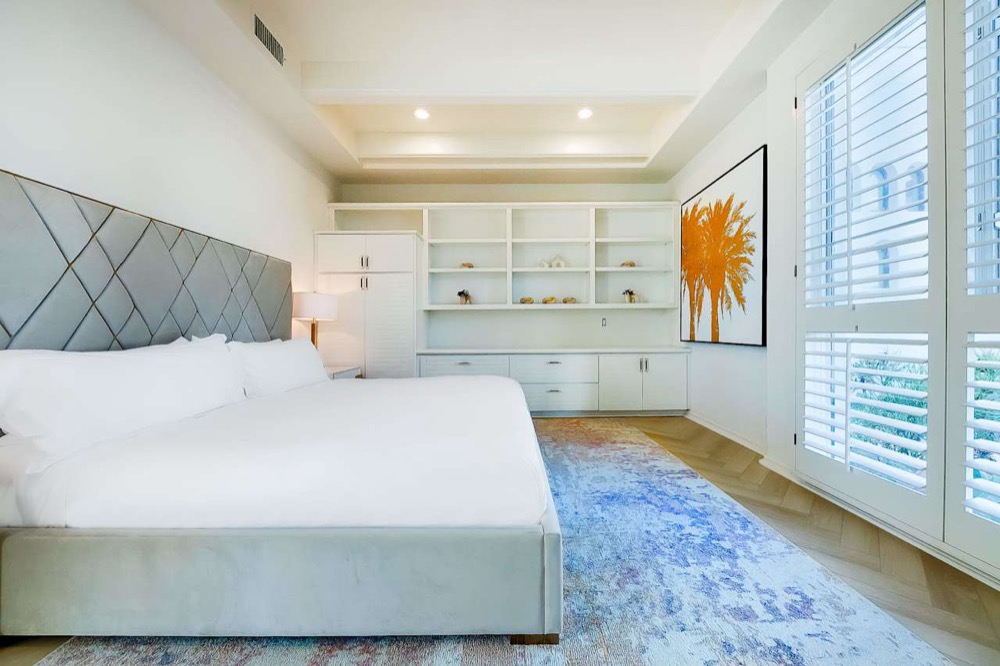 Shared room with a king bed, plantation shutters, and soft natural light