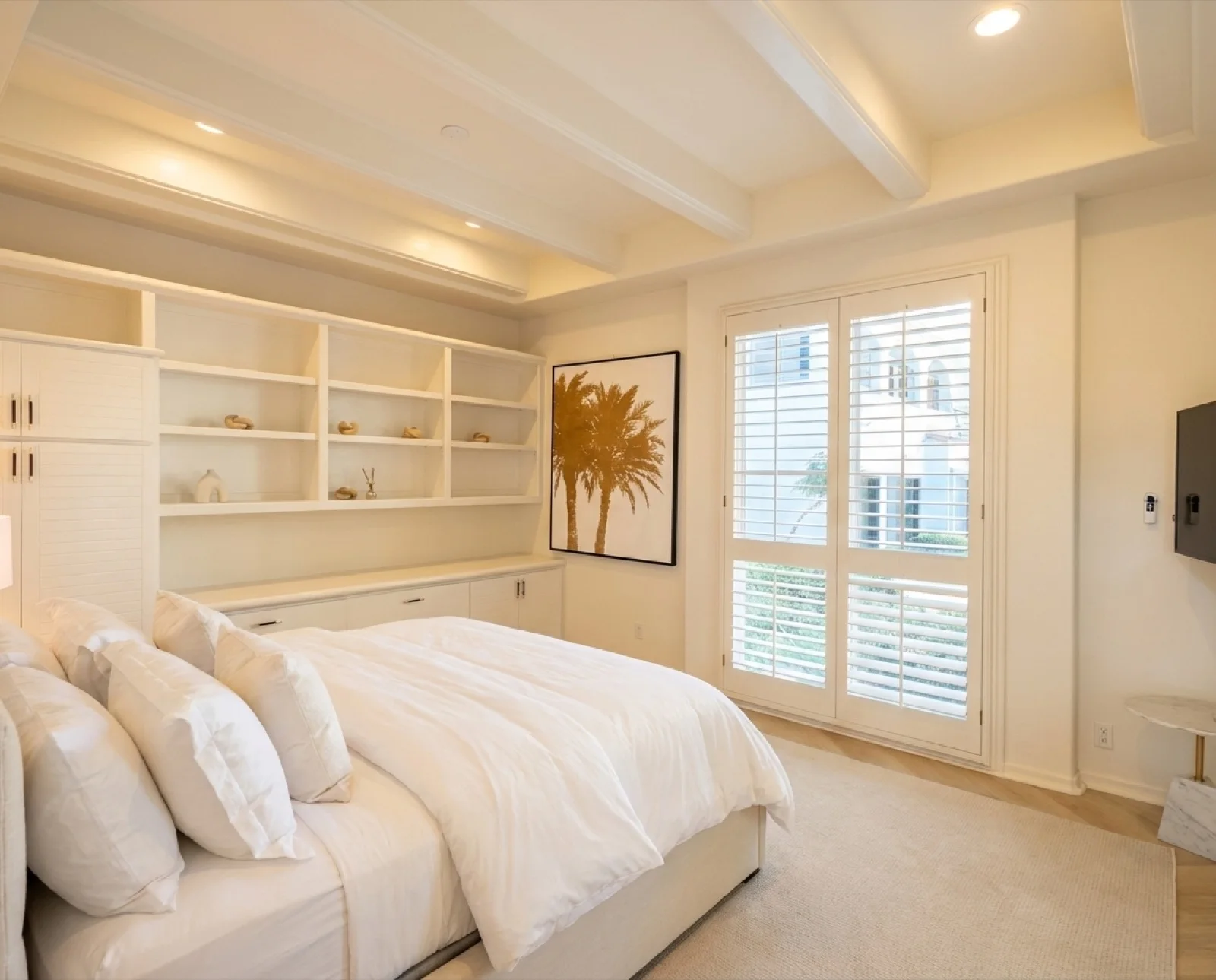 The Palm Room: a bright, spacious private bedroom with a king bed, beamed ceiling, and plantation shutters