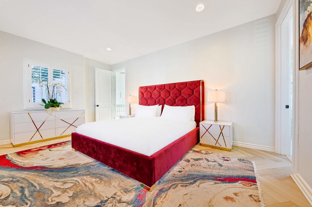 The Ruby Room: a private bedroom with a deep red velvet king bed and a painterly rug