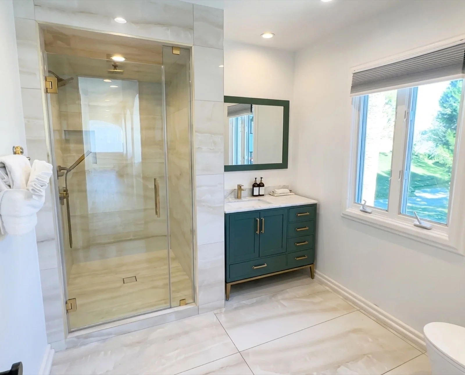 The marble spa bath the Ruby and Cloud rooms share, with a walk-in glass shower and garden window
