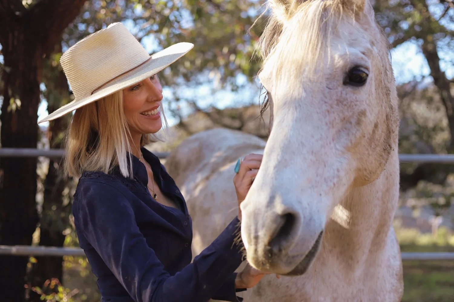 A woman connecting with a horse in the round pen at Shakti Ranch