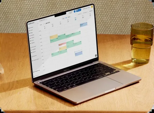 The SimplePractice calendar open on a laptop on a wooden desk