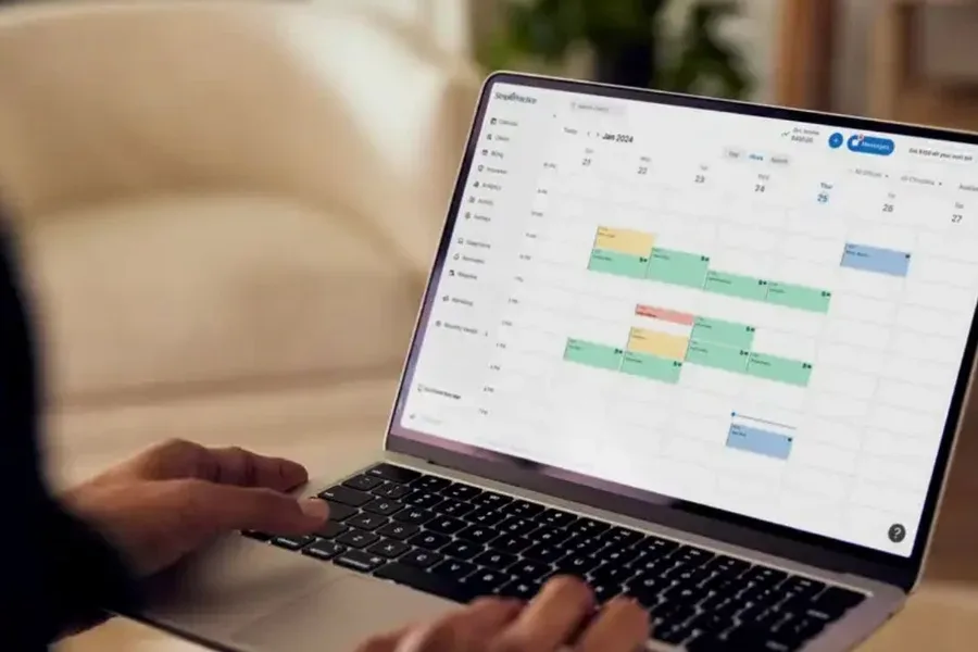 A therapist working in SimplePractice on a laptop